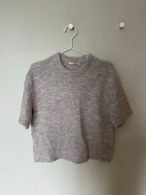 Grå stickad kortärmad tröja - Kortärmad stickad tröja från GinaTricot i ljusgrått. Använd enstaka  gånger så som ny!