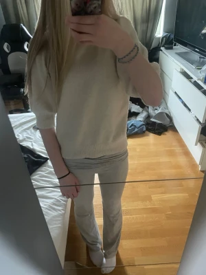 Vit puffärm stickad tröja - Säljer en vit stickad tröja med puffärmar och ribbade muddar. Tröjan har en avslappnad passform och är gjord i mjukt material, perfekt för en stilren vardagslook. Passar till både jeans och kjol.