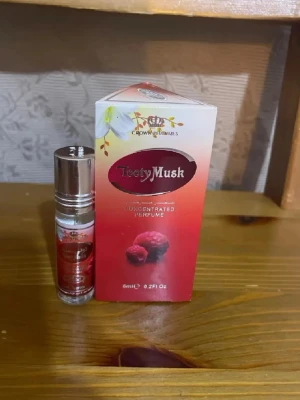 Tasty Musk parfymolja 6ml - Tasty Musk från Crown Perfumes är en koncentrerad parfymolja i en liten glasflaska med silverfärgat lock. Förpackningen är röd och vit med hallonmotiv och blommor, vilket ger en fräsch och söt känsla. Flaskan rymmer 6 ml och är smidig att ta med.