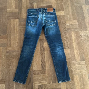 Replay Anbass slim jeans blå stl 30-32 - Säljer ett par Replay Anbass jeans i klassisk blå tvätt eftersom dem har blivit för små. Modellen är slim fit med normal midja och raka ben. Jeansen har fem fickor, dragkedjegylf och coola detaljer på bakfickorna. Perfekta för dig som gillar en smalare passform.