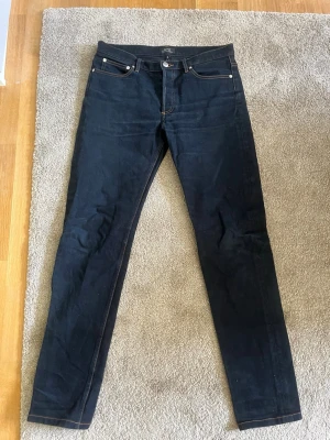 Mörkblå jeans från A.P.C. Petit New Standard i japanskt denim - Snygga mörkblå jeans från A.P.C. i modellen Petit New Standard. Klassisk femficksdesign med raka ben och kontrastsömmar. Jeansen är tillverkade i kraftig japanskt denim och har en stilren look som passar till det mesta.