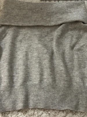 Beige «offshoulder» stickad tröja från H&M - En enkel och stilren grå stickad tröja från H&M. Materialet är mjukt och behagligt.