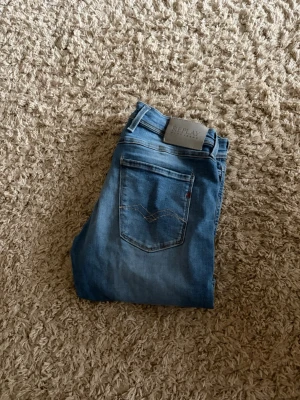 Blå jeans från Replay - Säljer ett par blå jeans från Replay med klassisk femficksdesign och snygga slitningar framtill. Jeansen har en ljus tvätt och raka ben. Perfekta till en avslappnad stil och tillverkade i mjukt denimtyg. Storleken som står i beskrivningen är inte för byxorna behövde bara trycka in en storlek för att kunna lägga upp jeansen storleken finns på bilderna.