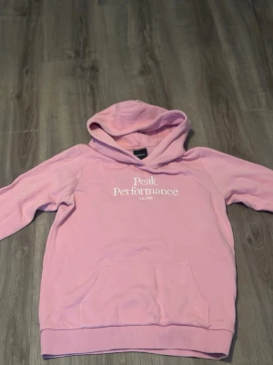 Peak Performance hoodie  - En rosa hoodie från Peak Performance i storlek 150. Använd några gånger men som ny på utsidan, lite nopprig på insidan men inget som syns. Inga hål eller permanenta fläckar. Tvättas innan den skickas 🩷