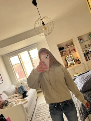 Ljusgrå hoodie med huva - Säljer en stilren ljusgrå/ljusgrön hoodie med huva och snören. Hoodien har en avslappnad passform, ribbade muddar vid ärmslut och nederkant. Perfekt för en chill och bekväm look. Passar till jeans eller mjukisbyxor.💗💞💓