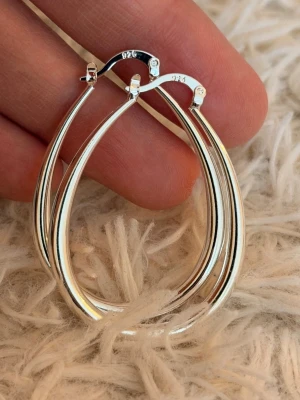 Droppformade örhängen i äkta silver - Snygga droppformade örhängen i äkta 925 silver med blank finish. De har en stilren och modern design med smidig låsning. Perfekta för dig som gillar minimalistiska accessoarer och vill ha något som sticker ut lite extra.