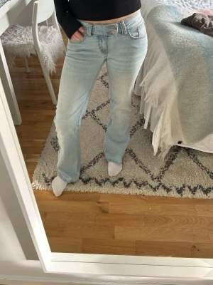 Ljusblå bootcut med låg midja  - Säljer ett par ljusblå jeans från lager 157 som har en låg midja med as snygg dragkedja. Mjukt och skönt material. Short längd på benen. 