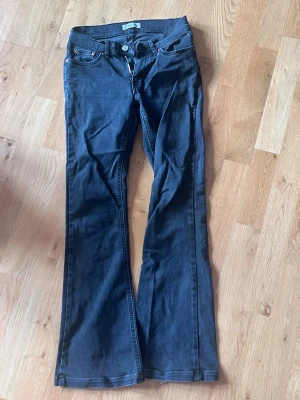 Mörkblå bootcut jeans stl 34 - Snygga mörkblå bootcut jeans med klassisk femficksmodell och dragkedja. Jeansen har en något utsvängd passform nedtill och är tillverkade i ett mjukt denimtyg. Perfekta till sneakers eller boots för en avslappnad look.