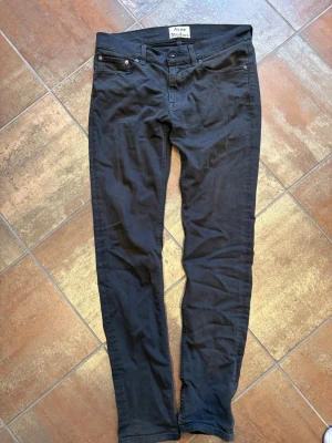 Svarta skinny jeans Acne Studios - Säljer ett par svarta skinny jeans från Acne Studios. Jeansen har klassisk femficksmodell, smal passform och normal midja. Materialet är mjukt och stretchigt för extra komfort. Perfekta för dig som gillar en clean och stilren look.