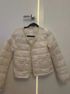 Vit pufferjacka från Gina Tricot - Säljer en stilren vit pufferjacka från Gina Tricot. Strl 146/152, använd en gång 