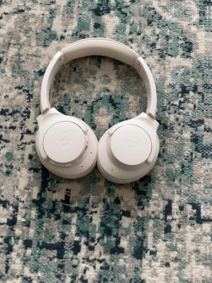 Vita over-ear hörlurar - Snygga vita over-ear hörlurar med vadderad bygel och mjuka öronkuddar. Sladdlösa och hopfällbara, perfekta för musik eller gaming. Modern design med diskret logga på kåporna.
