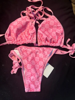 Rosa bikini - Snygg rosa bikini i en rosa nyans. Bikinin har trekantsöverdel med knytband i nacken och ryggen samt matchande trosa med knyt i sidorna. Perfekt för strand eller poolhäng.