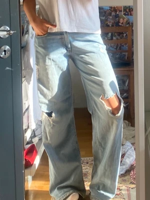 Baggy ljusblå jeans med hål - Baggy ljusblå jeans från Nelly!! i strl 36! Säljs för 400kr, nypris 600kr. Hålet på knät på högra benet har förstorats lite (så mycket som det är på bilderna!) 