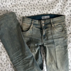 lågmidjade jeans - Populära lågmidjade bootcut jeans från Bershka. Nästan helt oanvända. Sytt upp de så de passar mig i längden som är 160 cm. Går att sprättas upp om man vill! Skriv för bilder på 🩷!!!!