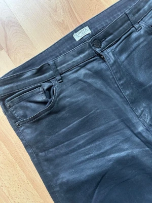 Svarta vaxade byxor  - Superfina svarta byxor från Lindex i modellen Nea. De har en snyggt vaxad/coatad yta som ger en lite dressad läderlook, men med komforten och stretchen av ett par vanliga jeans✨