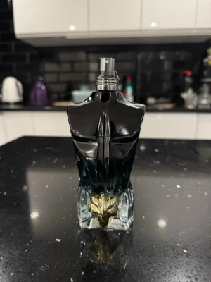 JPG le blue le parfum  - Snygg parfymflaska formad som en manlig torso i svart och mörkblått glas med en guldfärgad detalj framtill. Flaskan har en unik och stilren design som sticker ut i badrumshyllan.