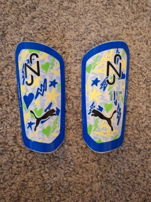 Puma Ultra Light 'Neymar JR' benskydd - Snygga Puma Ultra Light 'Neymar JR' besnkydd i storlek L. Skicket är mycket bra. Inga defekter eller skador finns. Skick: 8/10