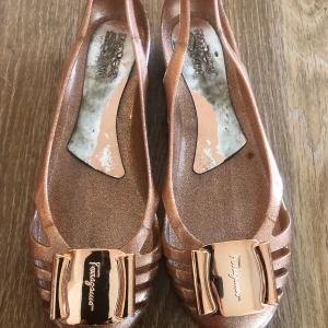 Ferragamo sandaler  - Jättesköna Ferragamoskor i kopparfärg. Väldigt bra skick - endast använda ett fåtal gånger!  Gummi material! Sjukt sköna!!