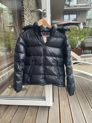 Moncler jacka - Jättesnygg Moncler-jacka som jag tyvärr inte använder längre, men som har mycket kvar att ge. Modellen är MAYA GIUBBOTTO. Jackan är en lite äldre modell och har därför en annan QR-kod, men om man skannar koden kommer man till Monclers hemsida.  Jackan är i bra skick, men tvättlappen har tyvärr lossnat. Storleken är 12, vilket motsvarar XS.  Jackan kostade mycket när jag köpte den, men eftersom tvättlappen har lossnat har jag sänkt priset ganska mycket.  Skriv gärna om du har några frågor! ❤️