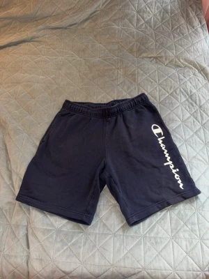 Två mjukisshorts - Säljer två stycken mörkblåa mjukisshorts. Den första är från Champion och den andra är från Lager 157, båda i storlek M. De från Champion har en fläck på baksidan.   OBS: Hör av dig om du bara vill ha en av shortsen