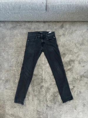 Replay anbass jeans  - Säljer ett par svarta skinny jeans från Replay med klassisk femficksmodell och diskret Replay-logga vid fickan. Jeansen har smal passform och är tillverkade i stretchigt denimtyg för extra komfort.