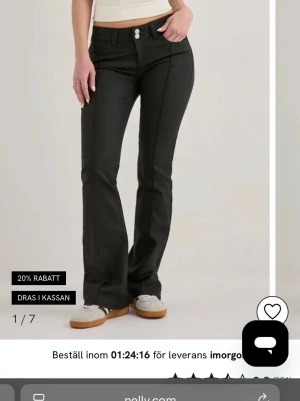 Svarta bootcut jeans från Nelly - Snygga svarta bootcut jeans från Nelly med hög midja och utsvängda ben. Jeansen har två knappar framtill, klassiska fickor och är tillverkade i ett stretchigt material för skön passform. Perfekta för en trendig och avslappnad look. Sprillans nya, aldrig använda i storlek 38, tyvärr inte prislapp kvar. 