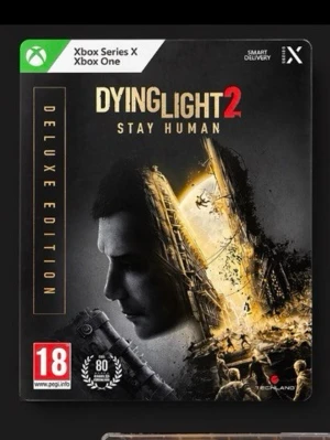 Dying Light 2 Deluxe Edition Xbox - Dying Light 2 Stay Human Deluxe Edition till Xbox Series X och Xbox One. Omslaget är svart och guld med apokalyptiskt motiv och spelets logga. Innehåller Deluxe Edition-material. Perfekt för dig som gillar actionfyllda zombiespel.