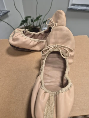 Ljus rosa ballerinaskor med rosett 39 TopShop - Säljer ett par klassiska rosa ballerinaskor med rund tå och dekorativ rosett framtill. Skorna har elastisk kant och är tillverkade i ett mjukt material som formar sig efter foten. Perfekta för dig som gillar enkel och stilren design.