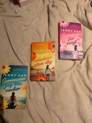 Sommaren-trilogin av Jenny Han - Säljer hela Sommaren-trilogin av Jenny Han: 'Sommaren jag blev vacker', 'Ingen sommar utan dig' och 'Sommaren för evigt'. Pocketböcker med färgglada omslag i blått, orange och rosa, prydda med blommor och somriga motiv. Perfekt för dig som gillar romantik och ungdomslitteratur. Köp en för 70 eller 3 för 170