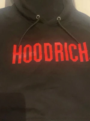 Hoodrich Hoodie  - Säljer en svart hoodie från Hoodrich med stor röd logga på bröstet. Hoodien har huva med dragsko. Använts ett par gånger endast. STORLEK: XL passar även L 