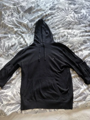 Svart hoodie från Polo Ralph Lauren - Säljer en svart hoodie från Polo Ralph Lauren med klassisk huva och dragsko. Tröjan har en känguruficka framtill och den ikoniska lilla loggan broderad på bröstet. Tillverkad i mjukt material som känns skönt mot huden. Perfekt för en avslappnad och stilren look, 100% kashmir. Priset kan diskuteras!