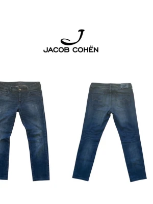 Mörkblå jeans från Jacob Cohën - Snygga mörkblå jeans från Jacob Cohën med smal passform och klassisk femficksdesign. Jeansen har lätt slitna detaljer och en diskret tvätt, skick 9/10 och inga hål eller defekter. Nypris:5000kr säljer dessa för endast 599kr