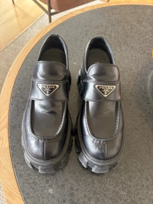 Chunky svarta loafers från Prada - Prada loafers med platå, inköpta 2024. Material: kalvskinn, storlek: 39, platå: 5 cm. 