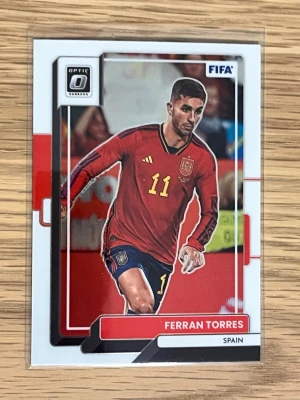 Ferran Torres samlarkort FIFA - Samlarkort från Panini Donruss Soccer med Ferran Torres i Spaniens landslagströja, nummer 11. Kortet har FIFA-logga och är designat i rött, vitt och svart med detaljer i guld. Perfekt för dig som gillar fotboll och samlar på sportkort. Optic