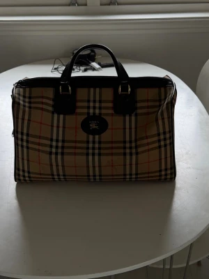 Burberry vintage duffel bag - Säljer nu min stilrena burberry duffel bag då den inte kommer till användning direkt! Men det är en vintage burberry väska som är väldigt snygg och passar till det mest. Skriv vid funderingar!! ÄKTHETS CERTIFIKAT FINNS
