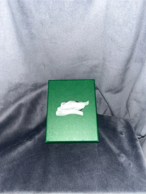 Svart plånbok - Snygg korthållare i svart med rutmönster i grå och brun. Kommer i en grön presentask. Perfekt för att hålla ordning på korten i fickan eller väskan. Tillverkad i ett material som ser ut som läder.