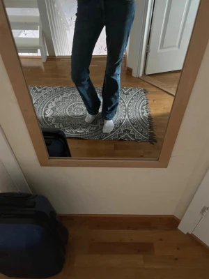 Mörkblå bootcut jeans - Säljer ett par mörkblå bootcut jeans med hög midja och klassisk femficksdesign. Jeansen har en snygg utsvängd passform från knät och ner, vilket ger en retrovibe. Perfekta till sneakers eller boots för en avslappnad look.