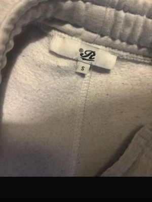 Grå mjukisbyxor från Russemerch  - Grå mjukisbyxor från Russemerch i storlek S. Byxorna har resår i midjan och är tillverkade i mjukt fleecematerial för extra komfort. Perfekta för en avslappnad stil och passar bra till hoodie eller t-shirt.