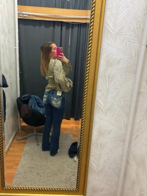 Blå bootcut-jeans Miss Me - Jeans från Miss Me. Använda 1 gång, nypris 2300kr! Super gott skick! Utsvänga jeans med låg midja, otroligt fina söm detaljer, vingar i rött och blått baktill samt stjärnor så det ska föreställa USA flagga!