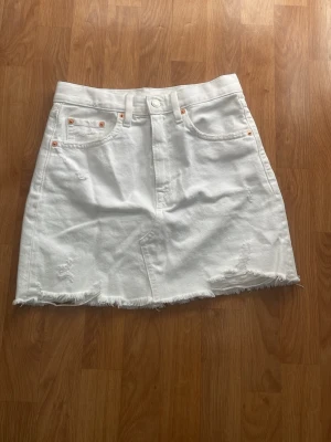 Vit jeanskjol från mango  - Snygg vit jeanskjol med rå, fransig kant och slitna detaljer. Kjolen är i väldigt bra skick då den inte har några defekter eller liknande. Kjolen sitter väldigt högt upp på mig men jag är 158 cm dock och drog upp den längre än va den egentligen ska sitta. Så är den hyfsat lång på mig ifall jag dra ner den. Passar perfekt någon som är längre än mig skulle kunna tänka mig.