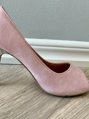 Rosa pumps med glittrig klack - Snygga pumps i ljusrosa med rund tå  och klackar täckta av silverglitter. Perfekt för dig som vill sticka ut med en glittrig detalj. Skorna har en klassisk siluett och är riktigt trendiga. Passar fest bröllop och vardag. 