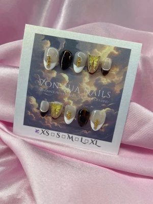 CocoaDrip (XS);Short Almond - Unika Handgjorda press-on naglar i svart, vitt och nude med guldiga detaljer och 3D-fjärilar. Korta av mandelform, vissa naglar har små guldfärgade ringar. Snygg och unik design för dig som vill sticka ut.XS: 14 mm, 11 mm, 11,5 mm, 10 mm, 8 mm 