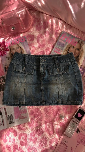 2000s jeanskjol - St 36 men skulle säga att den är mindre, kanske mer som en xs. Snygg blå vintage jeanskjol i kort modell med två framfickor med lock och knappdetaljer. Kjolen har bälteshällor och klassisk knappstängning framtill. Perfekt till sommaren. Den är köpt tidigt 2000tal men nästan aldrig använd. 