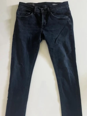 Mörkblå dondup jeans - Snygga mörkblå skinny jeans med klassisk femficksdesign och smal passform. Jeansen har en stilren look och är perfekta för dig som gillar en enkel men trendig stil.