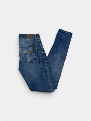  Nudie Jeans - Säljer ett par klassiska Nudie Jeans . De har fått lite slitage  fem fickor och Nudie-loggan på bakfickorna. Tillverkade i mjuk denim som sitter skönt hela dagen. 