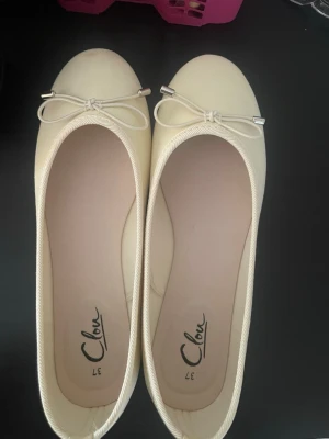 Helt nya Ljusgula ballerinaskor  - Helt nya ljusgula ballerinaskor från  med rund tå och dekorativ rosett framtill. 