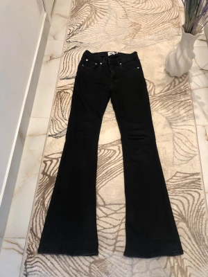 Svarta bootcut jeans från Lager 157 - Säljer ett par svarta bootcut jeans från Lager 157 med klassisk femficksdesign och utsvängda ben. Jeansen har knapp- och dragkedjeförslutning samt bakfickor. Perfekta för dig som gillar en retrostil och vill ha ett par jeans som sticker ut. Är öppen med prisförslag😊