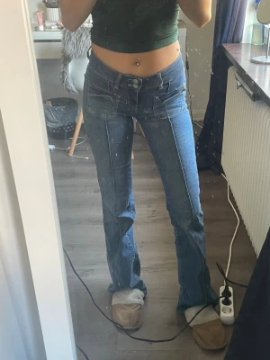 Blå bootcut jeans med fickdetaljer - Säljer ett par blå bootcut jeans med markerade sömmar och stora fickor framtill. Jeansen har låg midja ❣️❣️