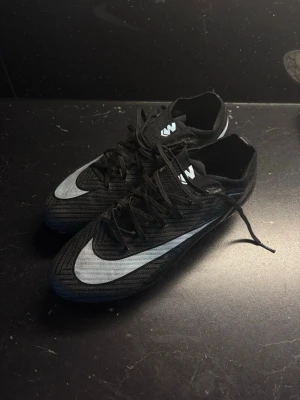 Nike Mercurial Elite - Säljer mina Nike Mercurial Elite FG då jag tyvärr har skadat mig och inte kommer kunna spela på ett tag.  Skorna är i bra skick med normalt slitage från användning. Dobbarna är fortfarande i fint skick och har mycket kvar att ge. Ovandelen är hel utan större skador.  * Elite-modell * FG (Firm Ground) – för naturgräs * Originalbox medföljer * Tappat bort elite bagen  |HÖR AV DIG VID FRÅGOR|