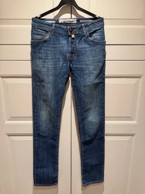 Blå jeans från Jacob Cohën - Snygga blå jeans från Jacob Cohën med klassisk femficksdesign och raka ben. Jeansen är i storlek 31 och modellen 622. Tillverkade i mjukt denimtyg som ger en skön passform och stilren look.